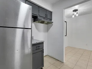 Kitchen and adjacent dining area with stainless refrigerator