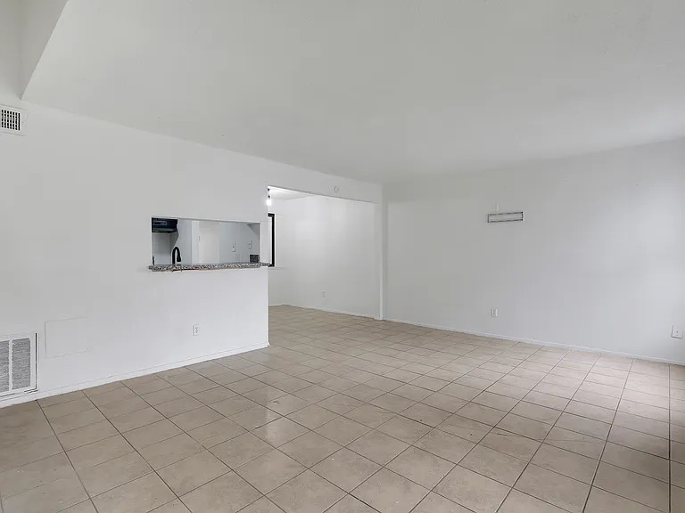 Tiled living and dining space with kitchen pass-through